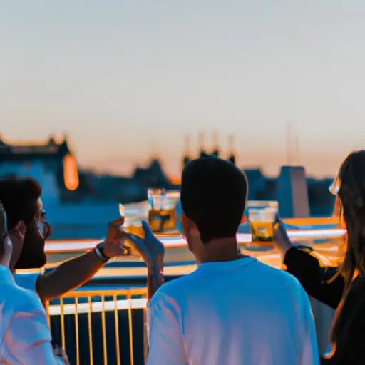 קבוצת חברים מרימה כוסית לטיול הבלתי נשכח שלהם במדריד בבר על הגג